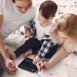 Parents and child enjoying drawing together on the floor, creating memories.